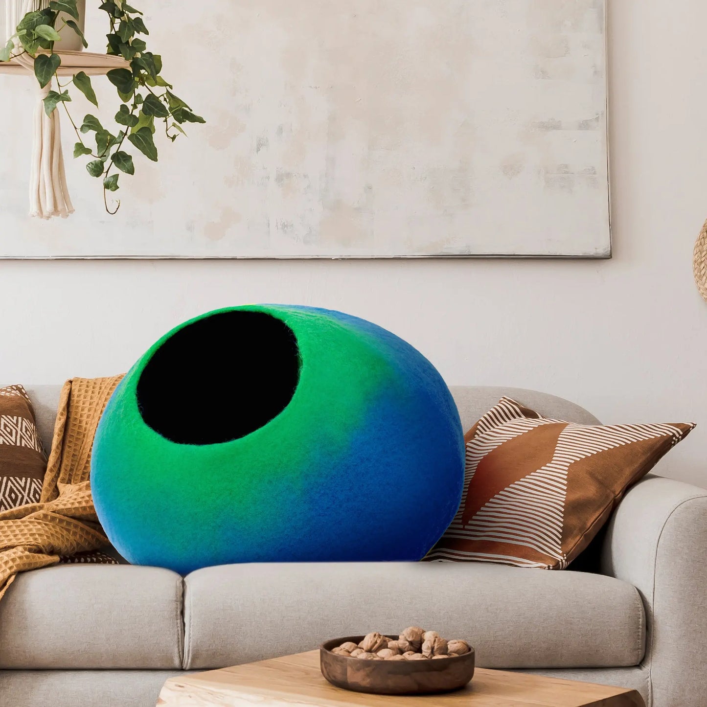 Handcrafted felted wool cat cave in warm earth tones, perfect for cozy cat naps. Circular design with a wide entrance for easy access. Soft and plush interior for comfort, providing a safe retreat for your feline friend. Ideal for cats of all sizes