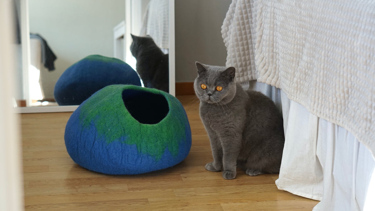 Grey cat beside blue green ombre wool cat cave on bedroom floor - handmade merino felt cat bed
